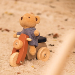 Kuschelbär in Strickpullover auf Holzmotorrad – nachhaltiges Spielzeug für Kinder